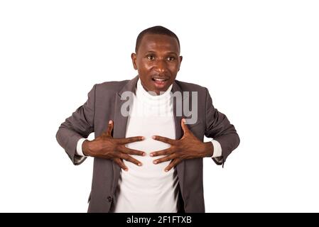 young man standing in a suit on a white background looking at the camera surprised. Stock Photo
