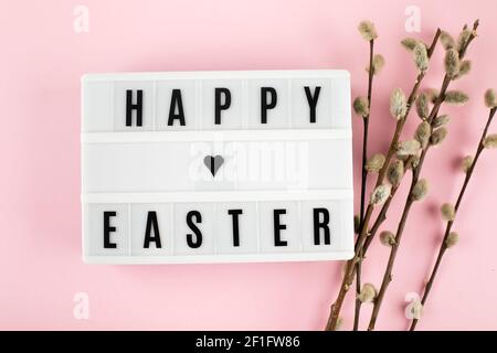 Easter spring holiday greeting card. Lightbox with text Happy Easter and branch of willow. Flat lay, top view Stock Photo