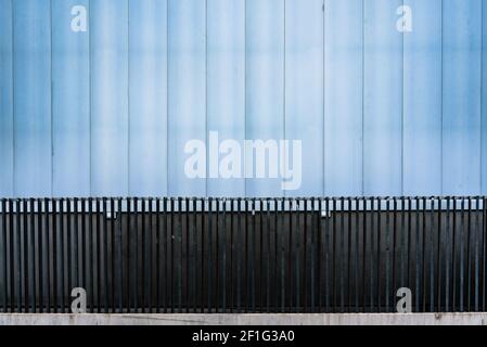 Facade of a door of an industrial warehouse made of gleaming aluminum and steel, simple and straightforward. Stock Photo