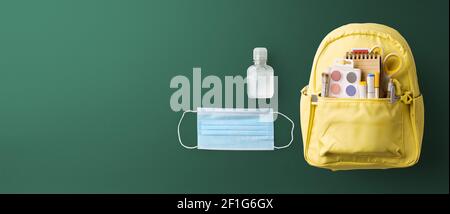 Flat lay top view of face mask and backpack, back to school and coronavirus concept. Stock Photo