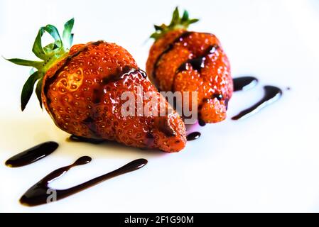 Strawberries with a tail drenched in liquid chocolate Stock Photo