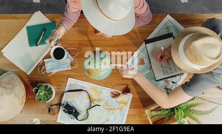 Top view of young couple with maps planning vacation trip holiday, desktop travel concept. Stock Photo
