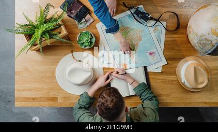 Top view of young couple with maps planning vacation trip holiday, desktop travel concept. Stock Photo