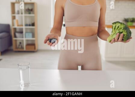 Body and hands of fitness woman athete in sportswear standing holding fresh healthy ingredients Stock Photo