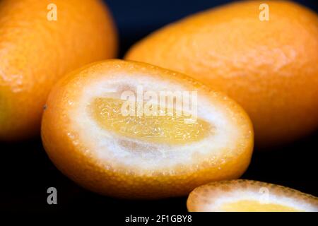 Yellow ripe kumquat on a black background. Exotic fruit. Stock Photo