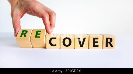 Time to recover symbol. Businessman turns wooden cubes and changes the word 'cover' to 'recover'. Beautiful white background. Business, cover or recov Stock Photo