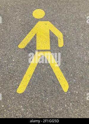 Yellow painted pedestrian crossing sign or pathway sign on asphalt in Switzerland Stock Photo