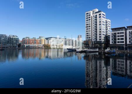 Grand Canal Docks in Dublin, Ireland with the Millennium Apartment Tower on the right and canal houseboats moored on the quayside. Stock Photo