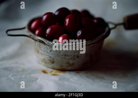 Fresh cranberries in vintage tea strainer. Selective focus on cranberries. Close up. Stock Photo