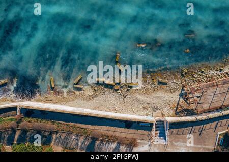 Aerial top view pf ocean coast with blue water and sea shore. Stock Photo