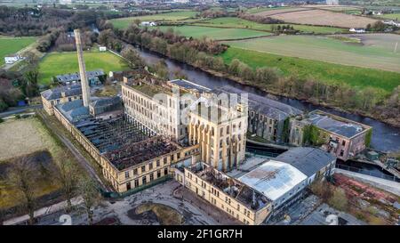 Sion Mills, Northern Ireland- Feb 27, 2021: Herdman' abandoned Flax Mill on the banks of the Mourne River in Sion Mills Stock Photo