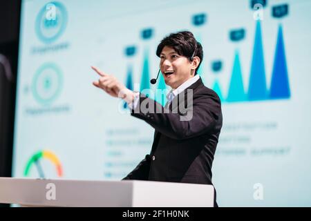Asian Businessman Stands on Stage for Business Presentation Stock Photo