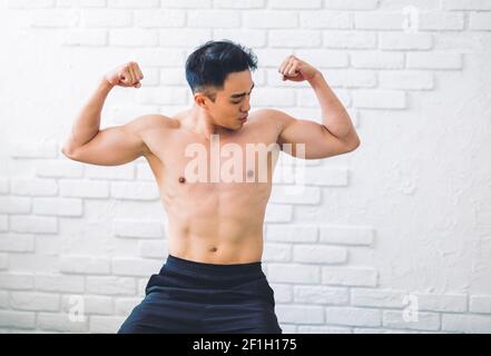 Muscular Asian young man doing  exercises at home Stock Photo