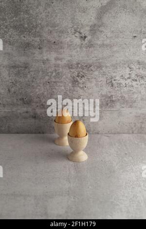two wooden eggs in wooden egg cups Stock Photo