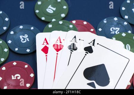 A closeup shot of four aces and different chips spread on a poker table Stock Photo