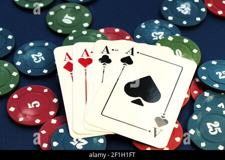 A closeup shot of four aces and different chips spread on a poker table Stock Photo