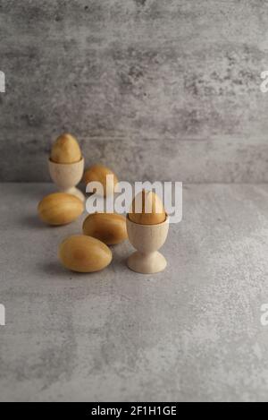 wooden eggs in wooden egg cups Stock Photo