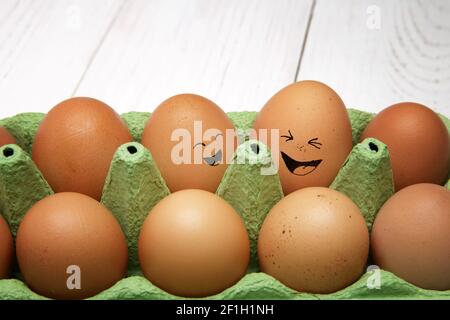 Emotional chicken eggs in a tray. Different grimaces drawn on chicken eggs Stock Photo