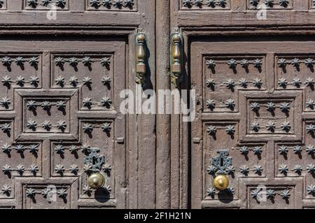 Rustic, wooden doors with iron knobs and handles in the entrance of an old palace in Almagro, Spain Stock Photo