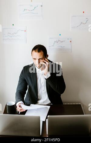 concentrated investment stock broker talking on phone in office Stock Photo