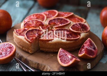 Homemade fruit cake. Blood orange slices on cake served on oak board closeup Stock Photo