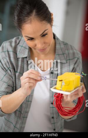 woman repairs an electrical box Stock Photo