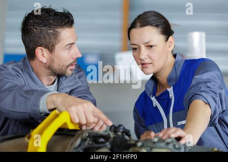 mechanics instructor teaching woman in apprenticeship Stock Photo