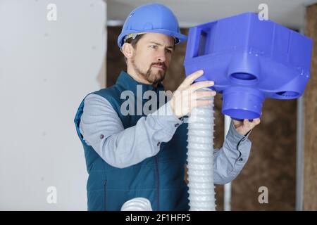 a plumber checking ceiling pipes Stock Photo
