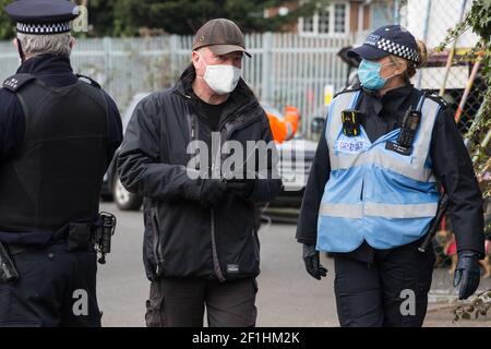 Sipson, UK. 8th March, 2021. Karl Harrison (c) of the National Eviction Team (NET) speaks to a Metropolitan Police liaison officer during an operation to evict residents from the remaining section of a squatted off-grid eco-community garden known as Grow Heathrow. Grow Heathrow was founded in 2010 on a previously derelict site close to Heathrow airport in protest against government plans for a third runway and has since made a significant educational and spiritual contribution to life in the Heathrow villages which are threatened by airport expansion. Credit: Mark Kerrison/Alamy Live News Stock Photo