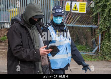 Sipson, UK. 8th March, 2021. A Metropolitan Police liaison officer uses coronavirus legislation to ask a man to vacate the area during an operation to evict residents from the remaining section of a squatted off-grid eco-community garden known as Grow Heathrow. Grow Heathrow was founded in 2010 on a previously derelict site close to Heathrow airport in protest against government plans for a third runway and has since made a significant educational and spiritual contribution to life in the Heathrow villages which are threatened by airport expansion. Credit: Mark Kerrison/Alamy Live News Stock Photo