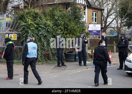 Sipson, UK. 8th March, 2021. A Metropolitan Police liaison officer uses coronavirus legislation to ask a woman to vacate the area during an operation to evict residents from the remaining section of a squatted off-grid eco-community garden known as Grow Heathrow. Grow Heathrow was founded in 2010 on a previously derelict site close to Heathrow airport in protest against government plans for a third runway and has since made a significant educational and spiritual contribution to life in the Heathrow villages which are threatened by airport expansion. Credit: Mark Kerrison/Alamy Live News Stock Photo