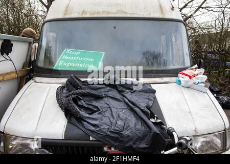 Sipson, UK. 8th March, 2021. A sign reading ‘Stop Heathrow Expansion’ is pictured in the front window of a vehicle during the eviction by bailiffs from the National Eviction Team (NET) of residents from the remaining section of a squatted off-grid eco-community garden known as Grow Heathrow. Grow Heathrow was founded in 2010 on a previously derelict site close to Heathrow airport in protest against government plans for a third runway and has since made a significant educational and spiritual contribution to life in the Heathrow villages which are threatened by airport expansion. Credit: Mark K Stock Photo