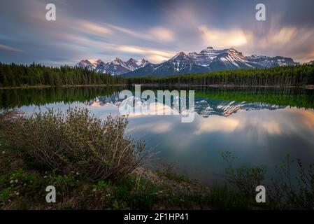 Evening light hitting the peaks of the Canadian Rockies while they reflect in Herbert Lake along the Icefields Parkway of Banff National Park. Stock Photo