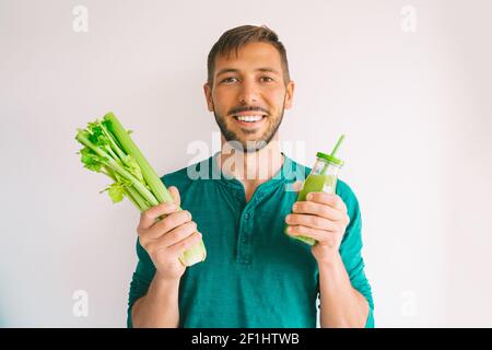 Healthy detox vegan diet. Man with celery and fresh homemade celery juice Stock Photo
