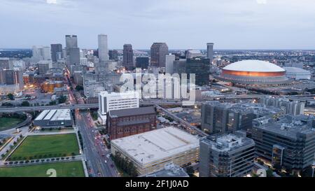 The Sun Peaks out through storm clouds lighting downtown New Orleans Stock Photo