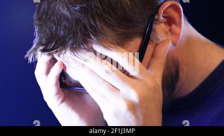Desperate man with his face in his hands, detail, footage represents feelings like depression, anxie Stock Photo