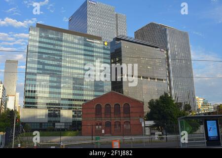 Old brick building preserved among modern city architecture of high rise buildings with glass exterior walls. Stock Photo