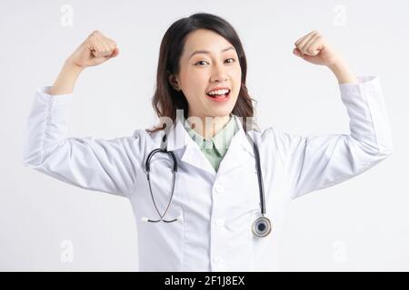 Asian female doctor holding up her hands in a strong shape Stock Photo