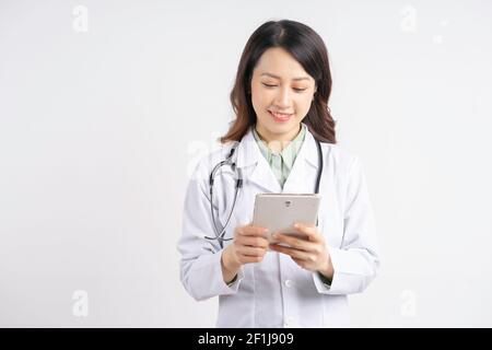 Portrait of asian female doctor using tablet standing smiling on white background Stock Photo
