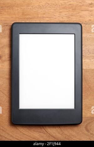 Electronic reader with blank screen on a wooden surface. Concepts of technology and reading. Image with copy space. Stock Photo