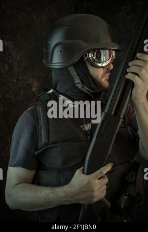 Thief, man armed with shotgun and bulletproof vest Stock Photo