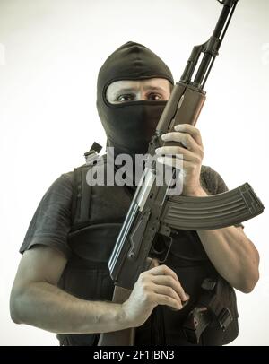 Thief, man armed with shotgun and bulletproof vest Stock Photo