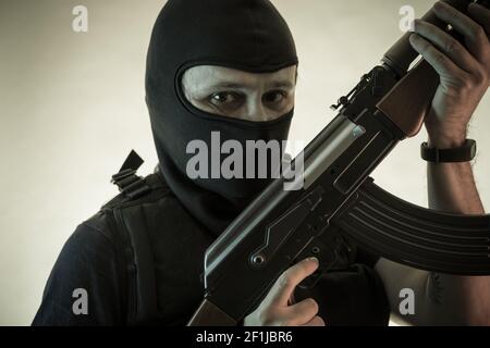 Thief, man armed with shotgun and bulletproof vest Stock Photo