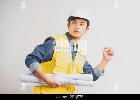 Asian construction engineer portrait holding the running drawing Stock Photo