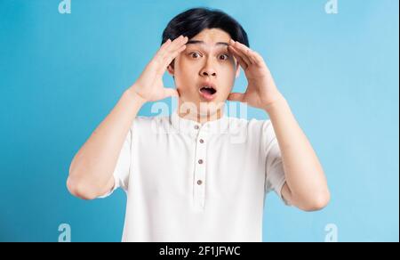 The Asian man was holding his head with his hands in disbelief Stock Photo
