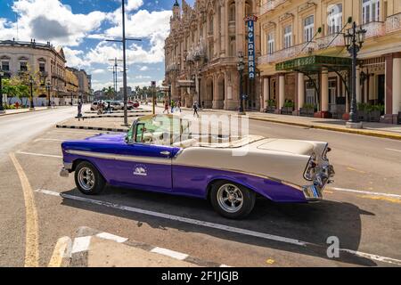 Havana Cuba. November 25, 2020: Old car from the Gran Car agency parked on an avenue in Havana with the Inglaterra hotel and the Gran Teatro de la Hab Stock Photo