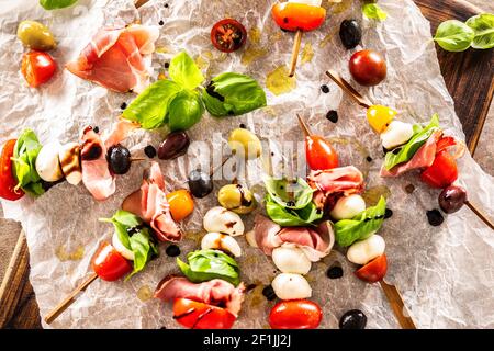 Caprese skewers italian or mediterranean appettizer tomatoes mozzarella olives and prosciutto Stock Photo