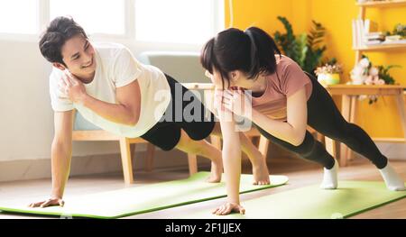 Asian couple doing exercise together at home Stock Photo