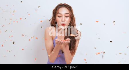 Girl at the party in a celebratory cap on a background of confetti Stock Photo