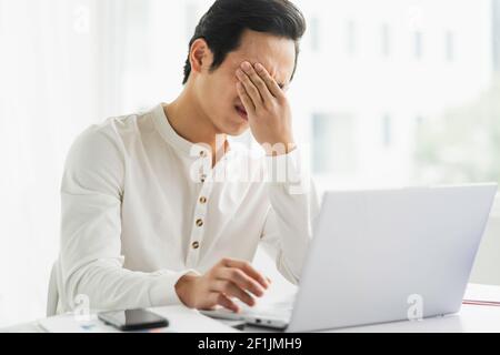 Male staff feel pressured and tired at work Stock Photo
